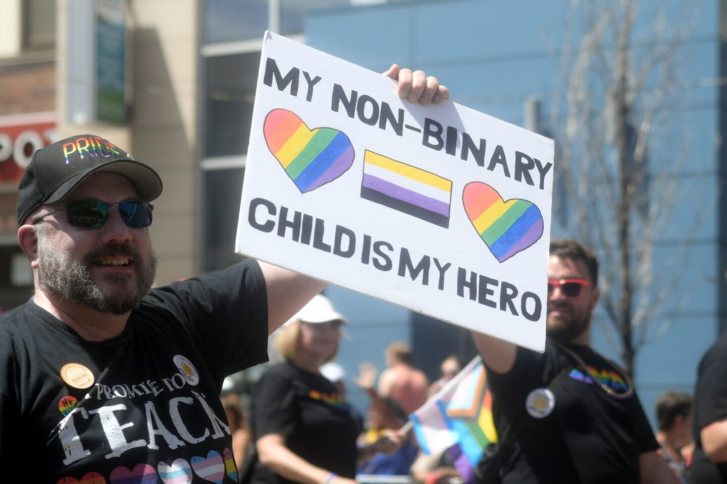 a man holding a non-binary sign