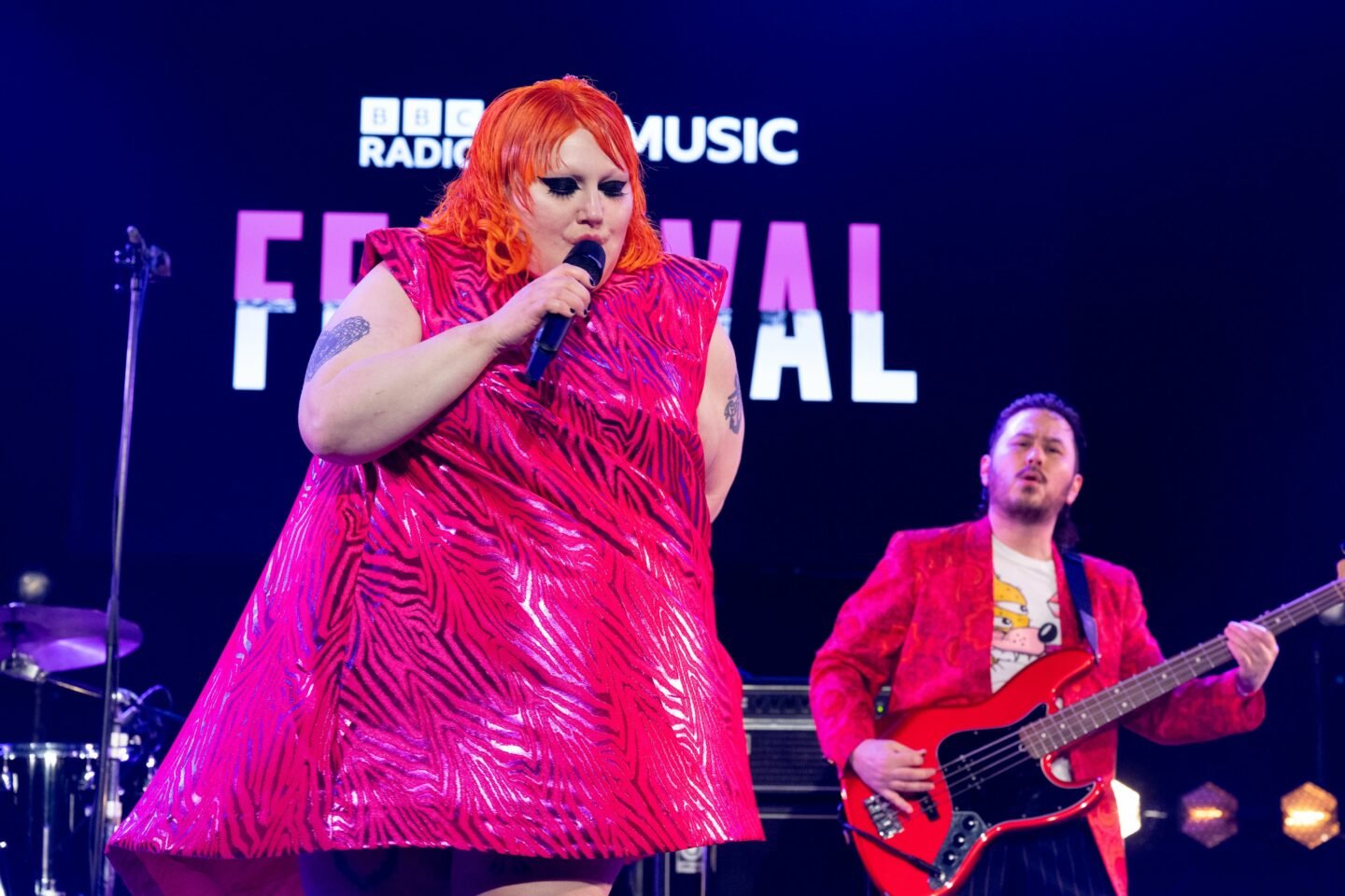 Beth Ditto performs in a hot pink dress onstage at BBC 6 festival with her band Gossip
